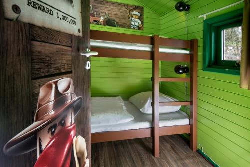 a room with a bunk bed in a green room at LEGOLAND Wilderness Barrels & Cabins in Billund