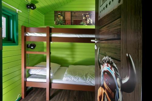 a room with green walls and bunk beds in it at LEGOLAND Wilderness Barrels & Cabins in Billund