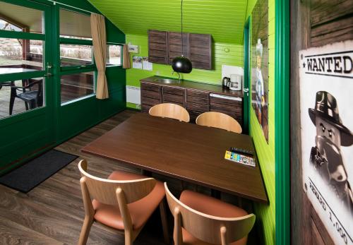 a dining room with green walls and a table and chairs at LEGOLAND Wilderness Barrels & Cabins in Billund