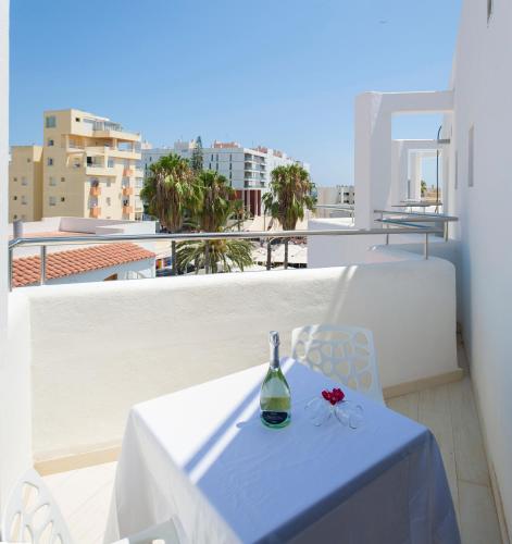 a bottle of wine sitting on a table on a balcony at My Way Luxury Ibiza Studio - AB Group in Playa d'en Bossa