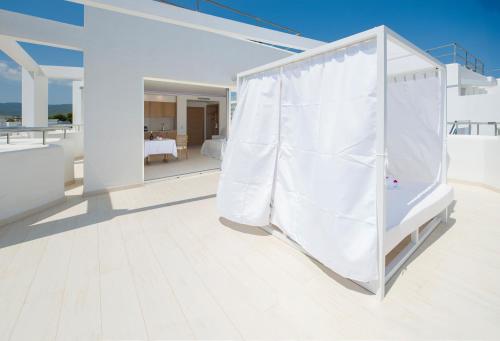 a white room with a bed with a white curtain at My Way Luxury Ibiza Studio - AB Group in Playa d'en Bossa