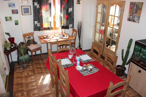 a dining room with a red table and chairs at Belle's Retreat in Saint-Jean-de-Sauves