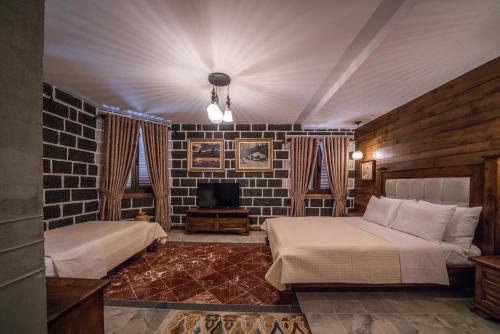 a bedroom with two beds and a tv in it at Korça Boutique Hotel in Korçë