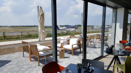 a restaurant with a view of an airport runway at Najeti Hôtel Lille Nord in Bondues