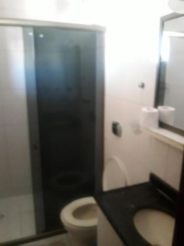 a bathroom with a toilet and a shower stall at Edificio caminho do sol in Arraial do Cabo