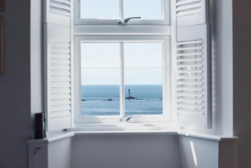 an open window with a view of the ocean at The Land's End Hotel in Sennen