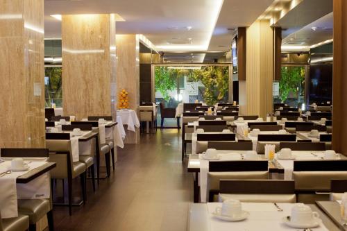 a dining room with white tables and chairs at TURIM Av. Liberdade Hotel in Lisbon