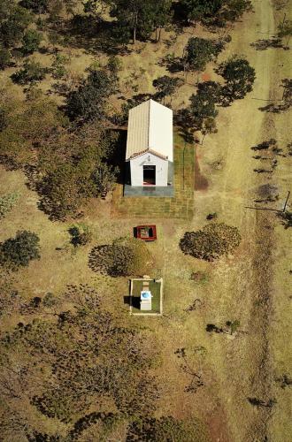 an aerial view of a white barn in a field at Pousada Refúgio da Serra in Pirenópolis