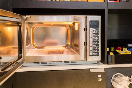 a microwave oven with a piece of food inside at Bugan Recife Boa Viagem Hotel - by Atlantica in Recife