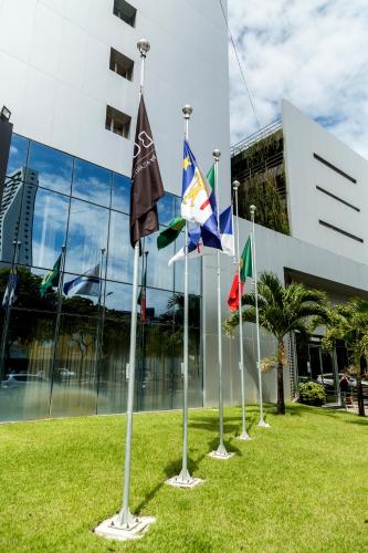 a row of flags in front of a building at Bugan Recife Boa Viagem Hotel - by Atlantica in Recife