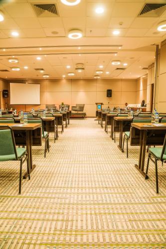 an empty classroom with tables and chairs and a chalkboard at Bugan Recife Boa Viagem Hotel - by Atlantica in Recife