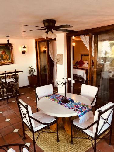 a table and chairs in a living room with a ceiling fan at Casa Miura Hotel Boutique in Ajijic
