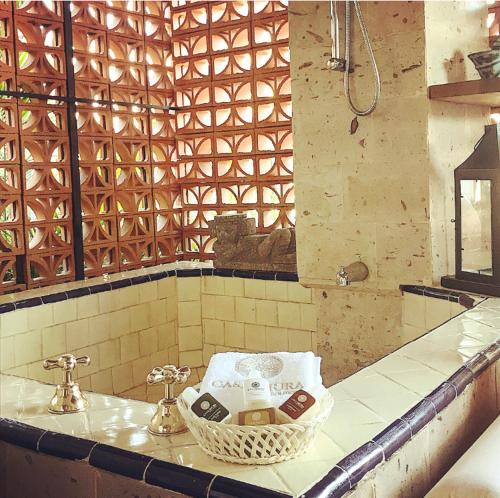 a bathroom with a sink and a basket of soap at Casa Miura Hotel Boutique in Ajijic