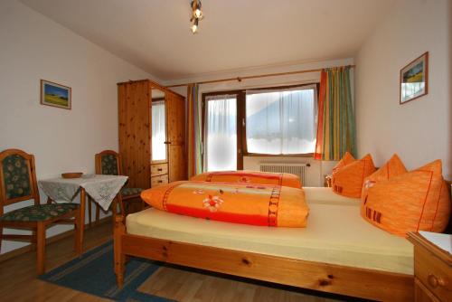 a bedroom with a bed and a table and a window at Haus St. Christoph in Mayrhofen