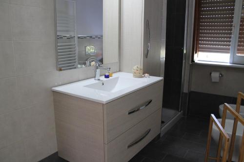 ein Badezimmer mit einem weißen Waschbecken und einem Spiegel in der Unterkunft Dafne Holiday in Agerola