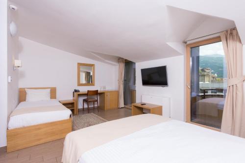 a hotel room with two beds and a television at Hotel Lirak in Tetovo