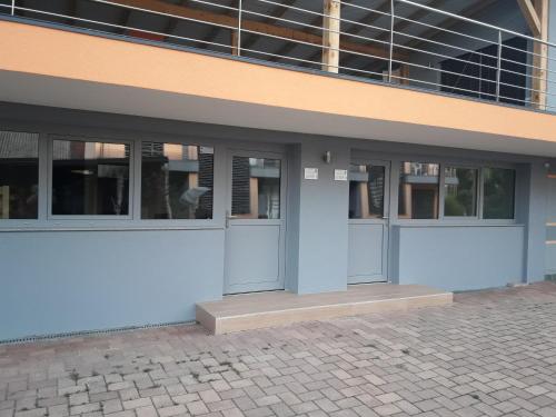 a building with doors and windows on a street at Apartments Akacijev Izvir in Miklavž na Dravskem Polju