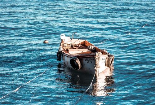 a small boat in the water in the ocean at Apartment Palma Madeira wandern und tauchen in Caniço
