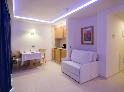 a living room with a white chair and a table at My Way Luxury Ibiza Studio - AB Group in Playa d'en Bossa