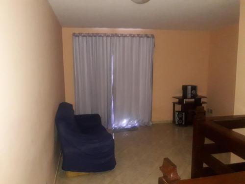 a living room with a blue couch and a window at Edificio caminho do sol in Arraial do Cabo