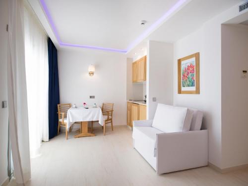a living room with a table and a white couch at My Way Luxury Ibiza Studio - AB Group in Playa d'en Bossa