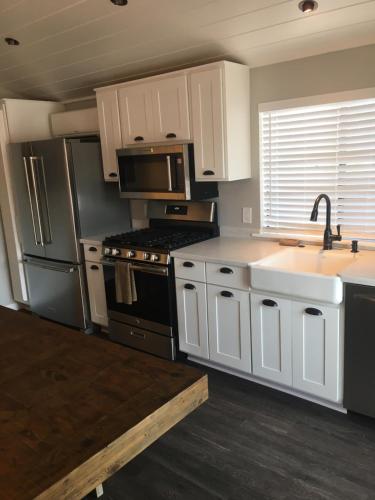 a kitchen with white cabinets and a stove and a sink at Flying Flags RV Resort & Campground in Buellton