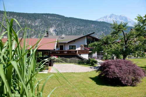 a house with a large yard with mountains in the background at Hotel Thaler in Rietz