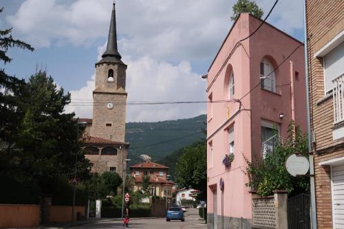 a street with a church steeple and a pink building at Sweet Dreams in Campdevánol