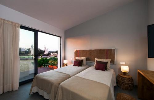 a bedroom with two beds and a large window at Agroturismo Xistos in Cerca