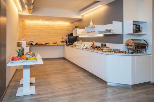 a large kitchen with a counter with food on it at Hotel Villa Alberta in Nago-Torbole