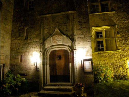 an old stone building with a door at night at Château de Fourcès in Fourcès