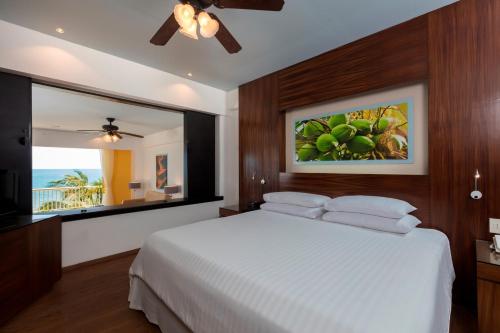 a bedroom with a white bed and a large window at Krystal Grand Nuevo Vallarta in Nuevo Vallarta 