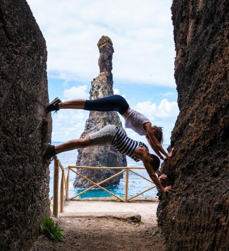 a man doing a handstand in front of a rock at Apartment Palma Madeira wandern und tauchen in Caniço