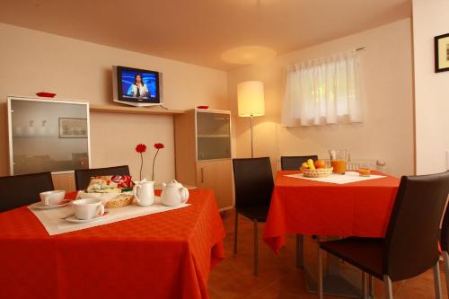 a dining room with two tables with red table cloth at Levidom Residence Rooms in Levice