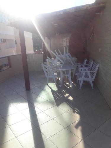 a group of white chairs and tables on a patio at Edificio caminho do sol in Arraial do Cabo
