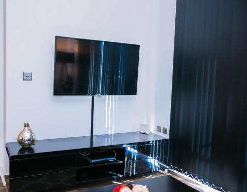 un armadio nero con una televisione sopra di MODERN 2 BEDROOM APARTMENT a Londra