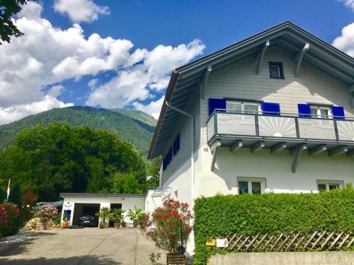 a white house with a balcony and mountains in the background at Ferienwohnung Karin in Bludenz