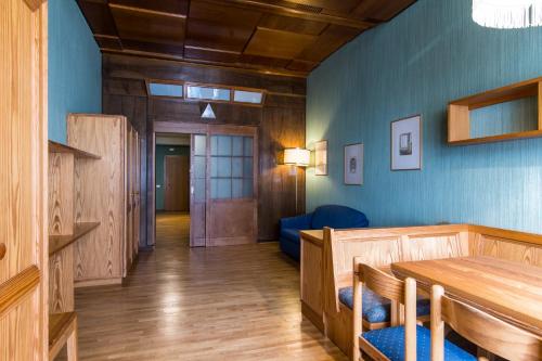 a living room with a table and a blue wall at Residence Grand Hotel Carezza in Nova Levante