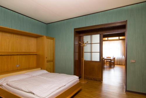 a bedroom with a bed and a room with a table at Residence Grand Hotel Carezza in Nova Levante