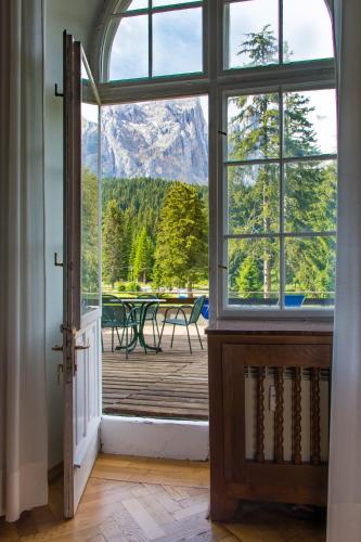 an open door to a patio with a view of the mountains at Residence Grand Hotel Carezza in Nova Levante