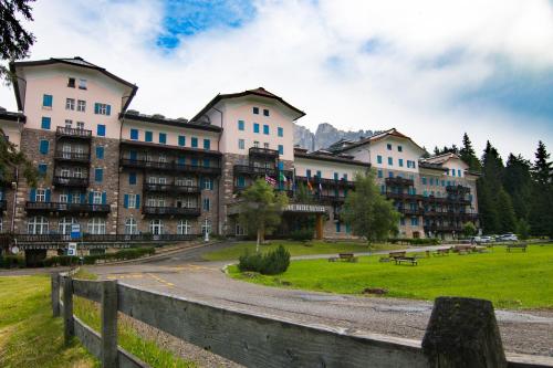 a large apartment building with a park in front of it at Residence Grand Hotel Carezza in Nova Levante
