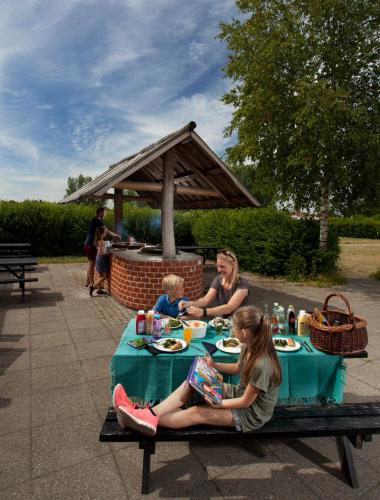 a woman and a child sitting at a table with food at LEGOLAND Wilderness Barrels & Cabins in Billund