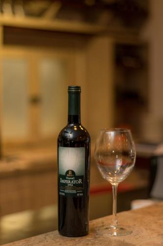 a bottle of wine next to a wine glass at Hotel Lirak in Tetovo