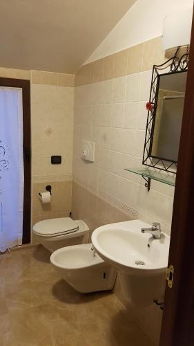 ein Badezimmer mit einem Waschbecken, einem WC und einem Spiegel in der Unterkunft Guest House in Palazzo San Gervasio