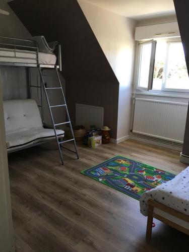 - une chambre avec des lits superposés et un tapis dans l'établissement maison 400 m de la plage, à Barneville-Carteret