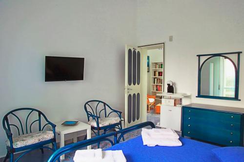 a room with two chairs and a table and a tv at Villa Doris in Fontane Bianche