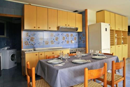a kitchen with a table and chairs and a kitchen with yellow cabinets at Villa Doris in Fontane Bianche