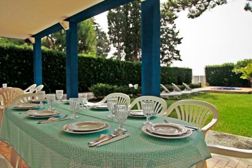 a table with plates and silverware on a green table cloth at Villa Doris in Fontane Bianche
