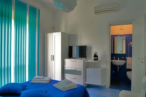 a bedroom with a blue bed and a bathroom at Villa Doris in Fontane Bianche