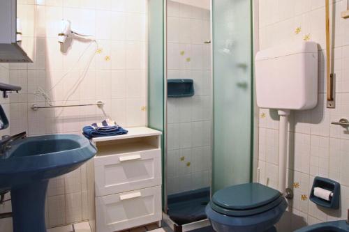 a bathroom with a blue toilet and a sink at Villa Doris in Fontane Bianche
